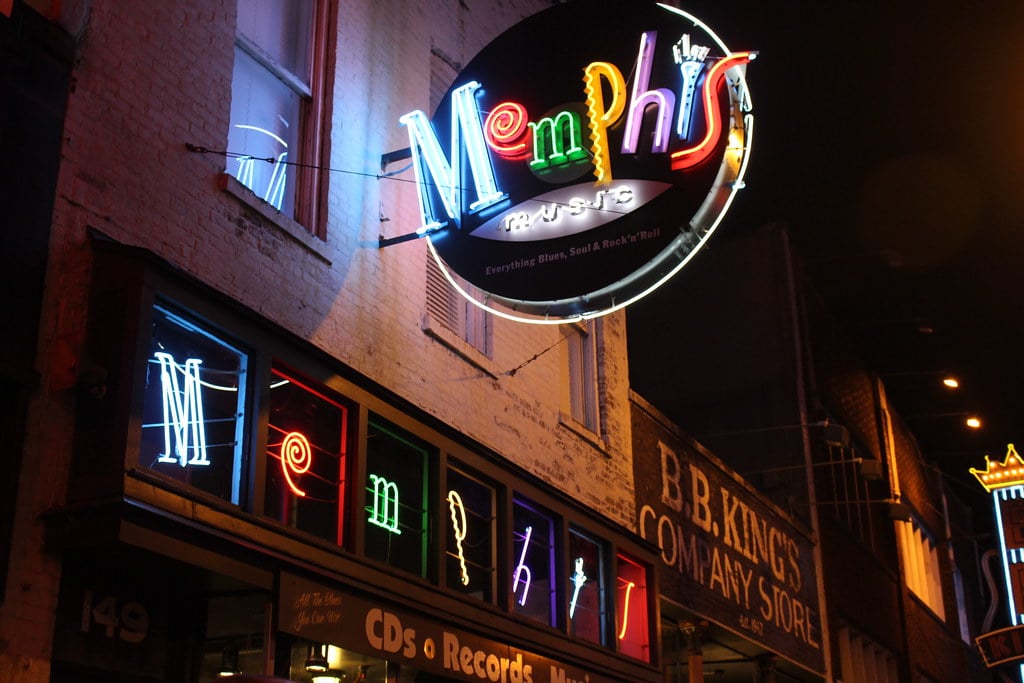 A neon sign on the side of a building at night in Memphis.