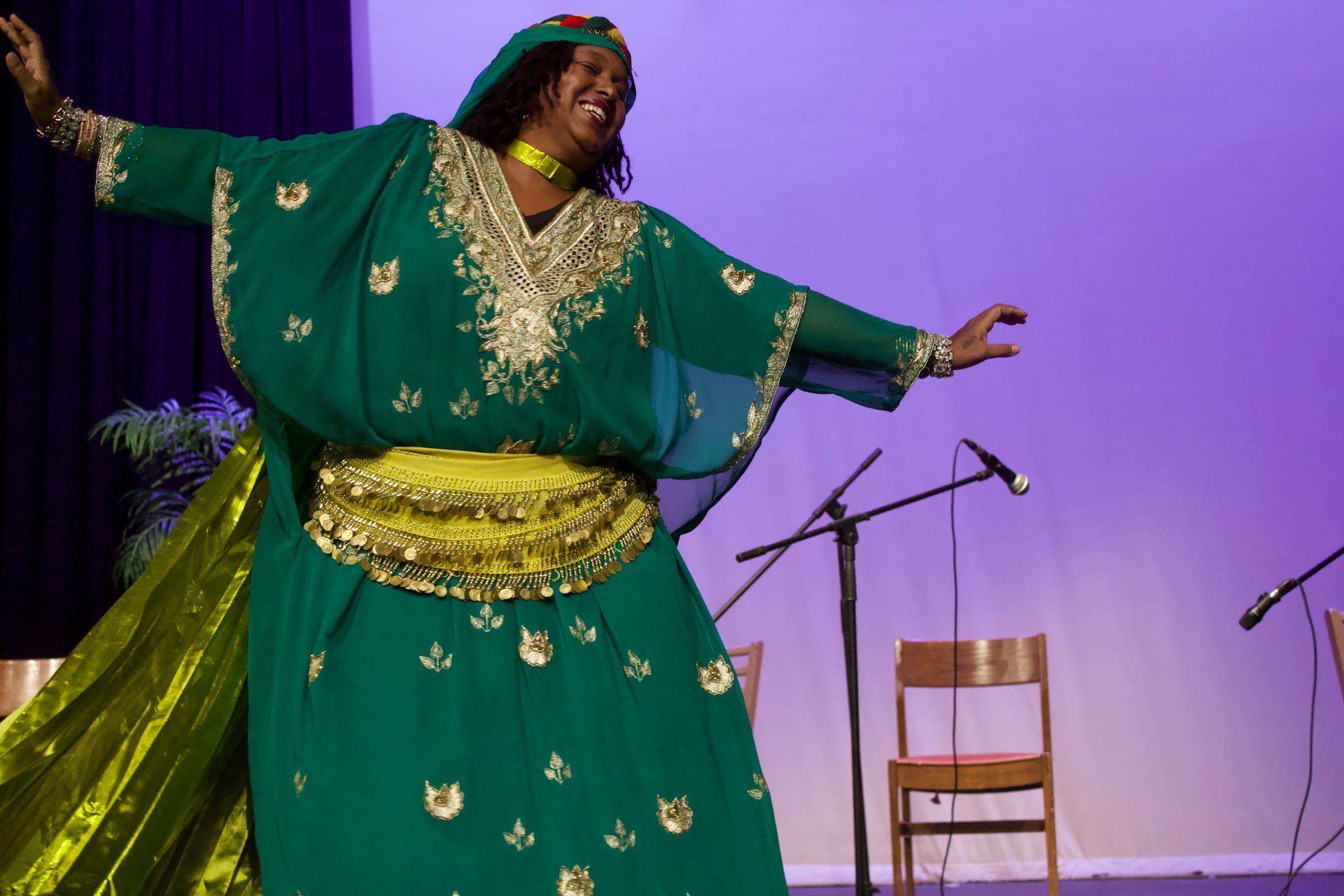 In a last performance, a woman in a green dress captivates the stage.