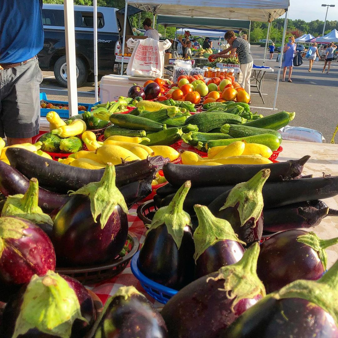A farmers market display of fresh produce including vegetables and fruits.