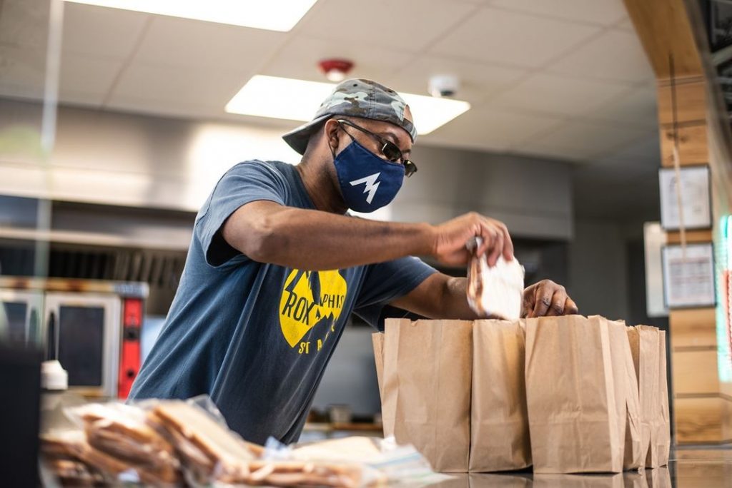 A man wearing a face mask serving food in Memphis as a volunteer.