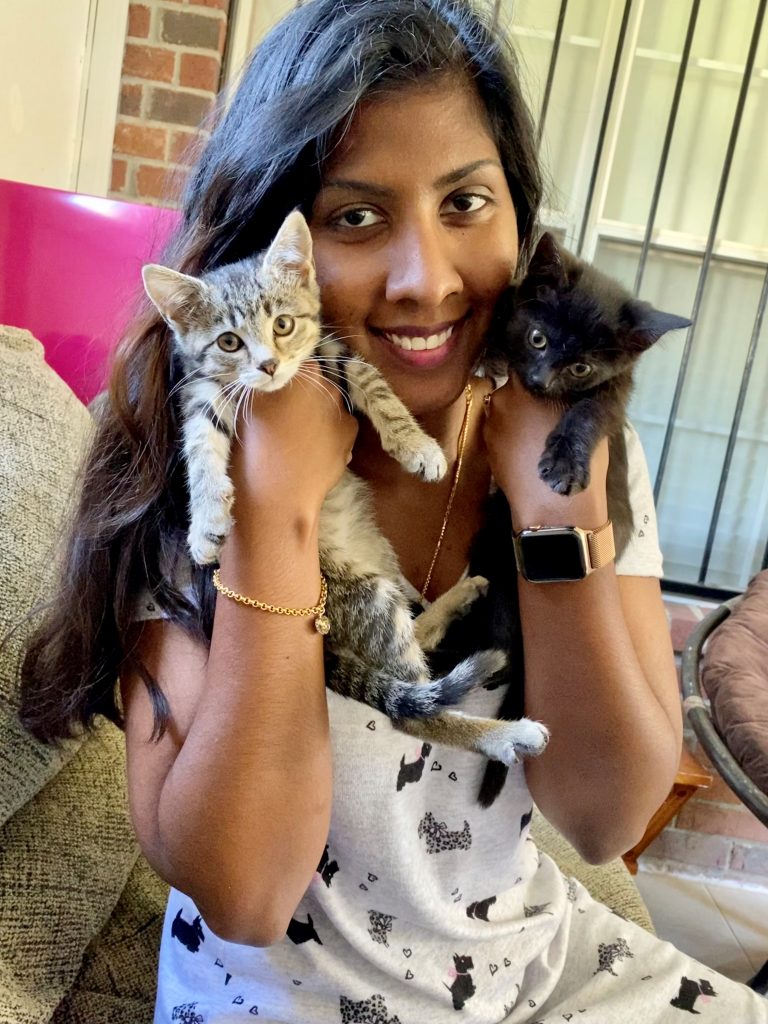 A woman holding two kittens on a Memphis Animal Foster couch.