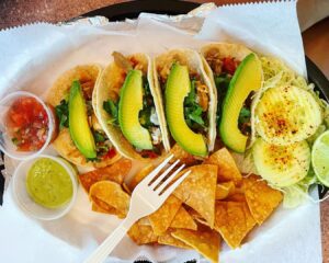 A plate of tacos and chips with guacamole and salsa in Memphis.
