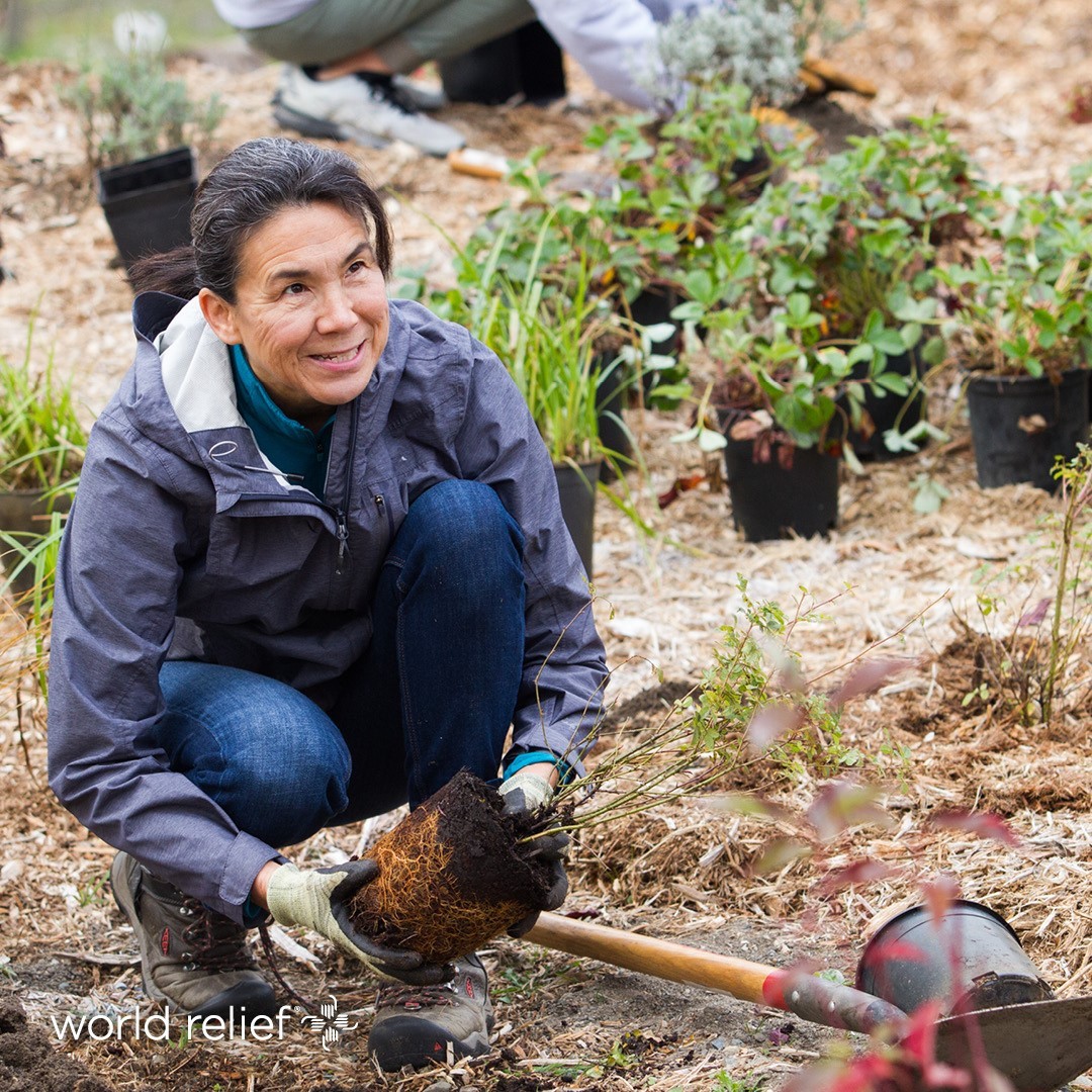 A woman volunteering in a garden at a Memphis nonprofit, digging with a shovel.