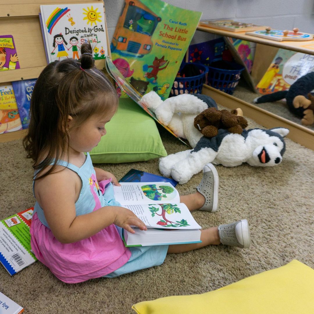 A little girl reading a book.