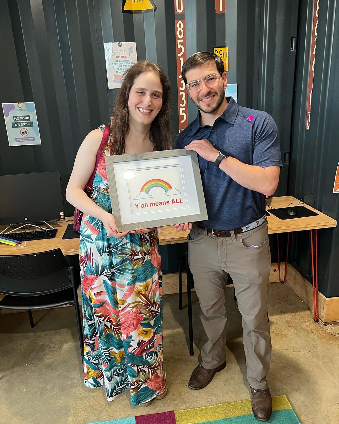 A man and woman holding a framed award in an office at a Memphis nonprofit.