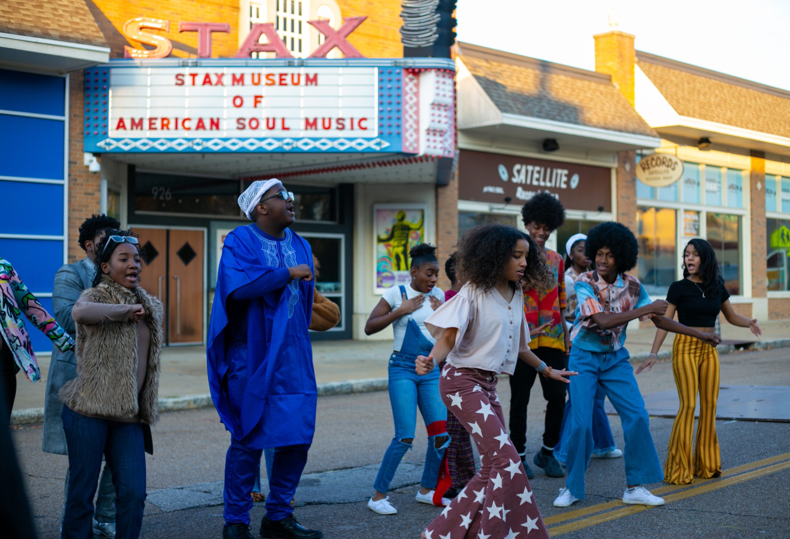 A group of people dancing in front of a theater, showcasing the Soul of America.