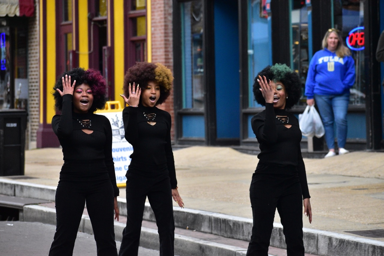 Three women with afros embody the soul of America on a street.