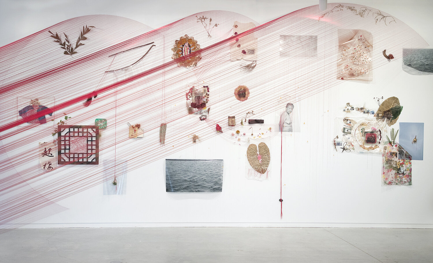 A white wall adorned with diverse artwork at Crosstown Arts Residency.