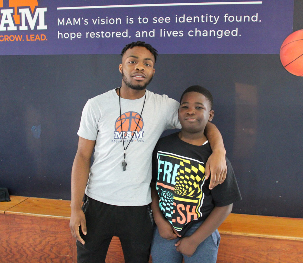 A man and a boy from Memphis Athletic Ministries posing for a picture.