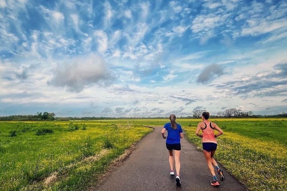 Two women jogging on an outdoor path.