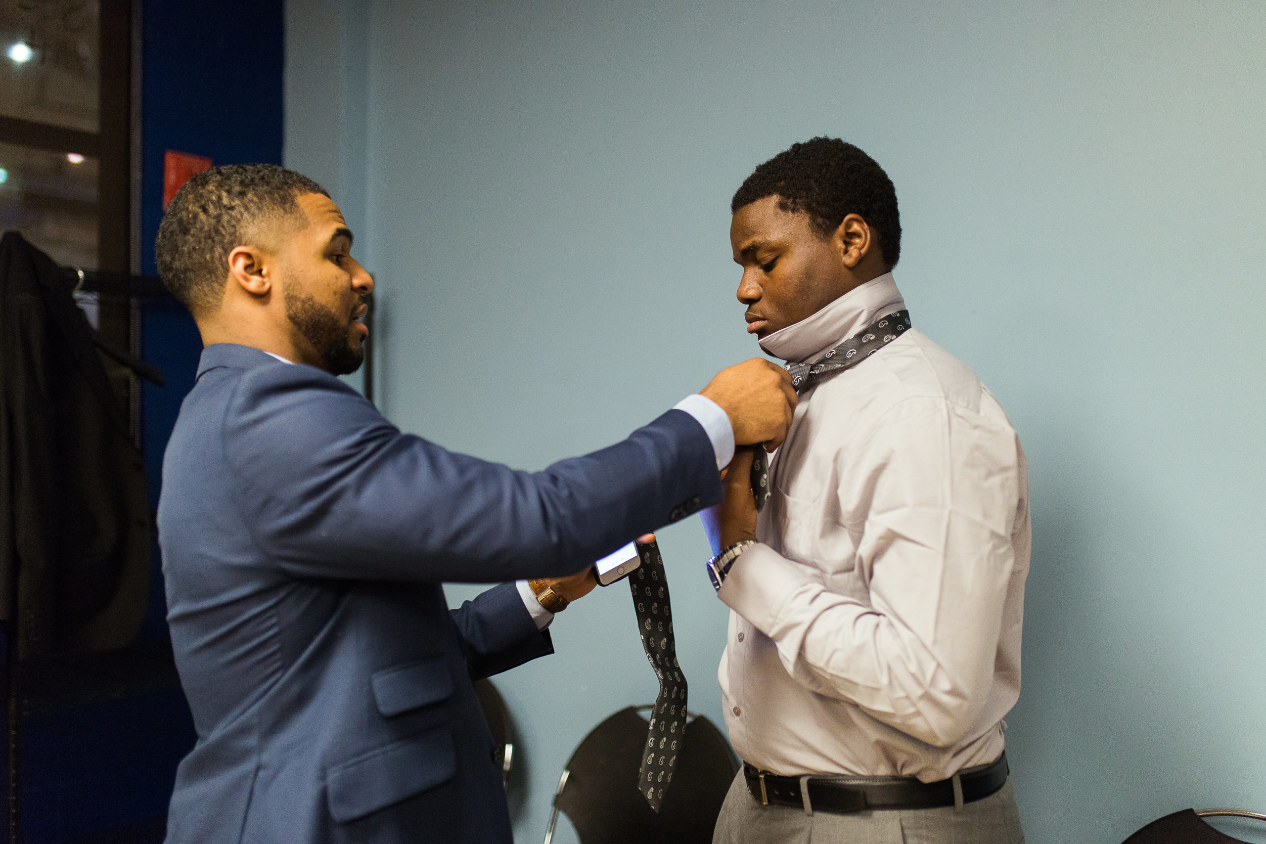 A man mentoring, adjusting another man's tie at the Mentoring Matters Summit.