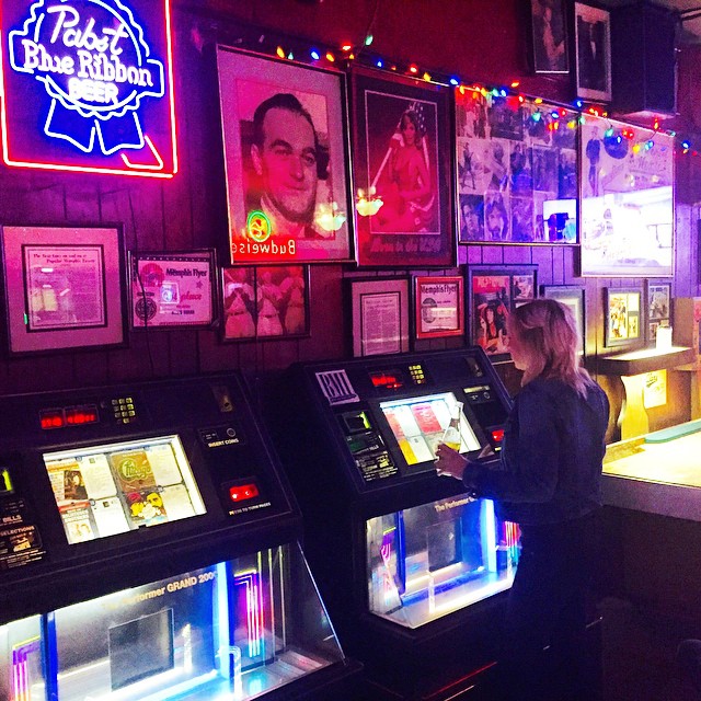 A woman standing in front of a machine in a bar.