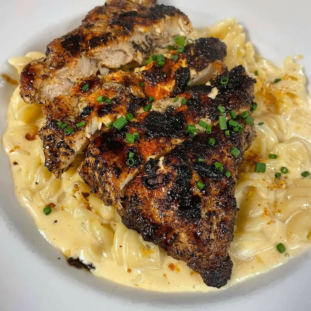 A plate with chicken and pasta on it.