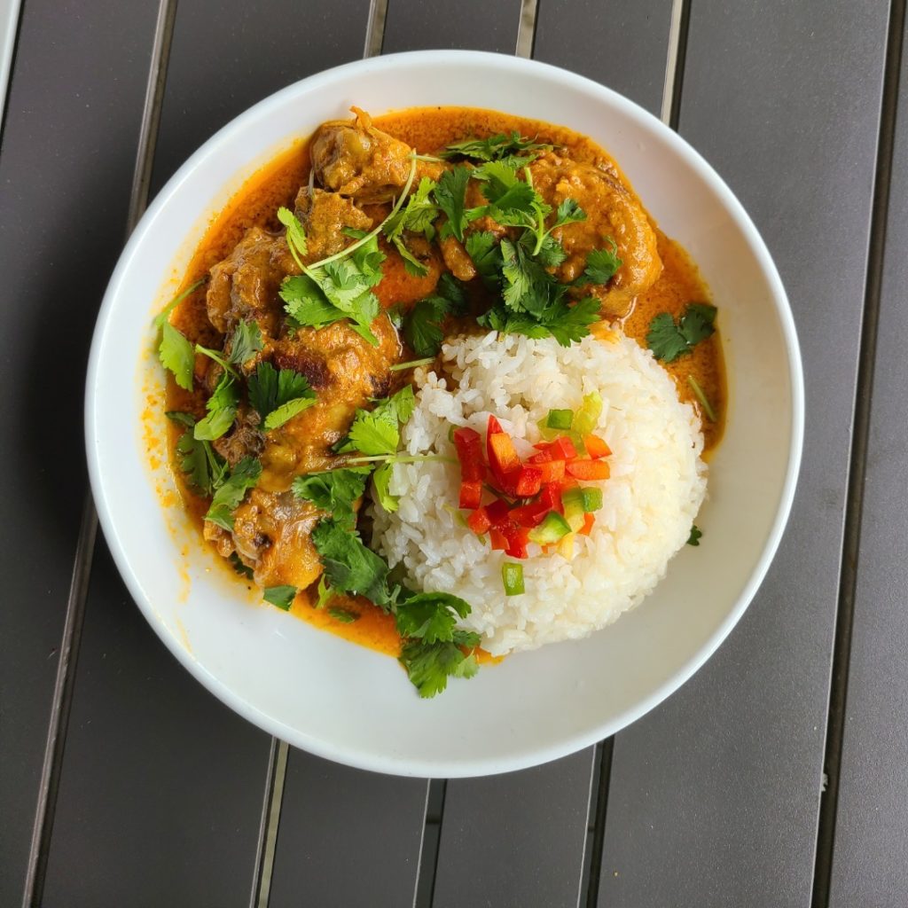 Thai chicken curry with rice on a table.