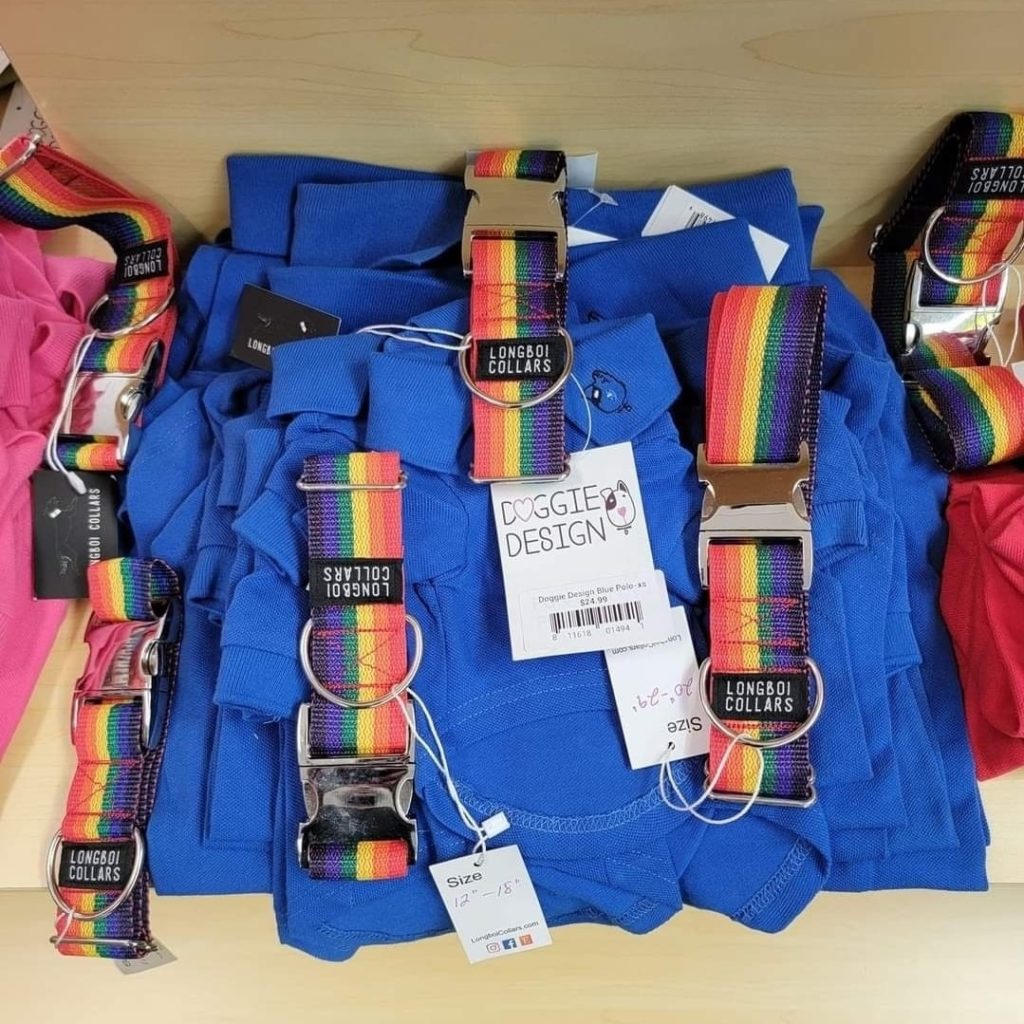 A rainbow - striped t-shirt and a rainbow - striped bag on a shelf.