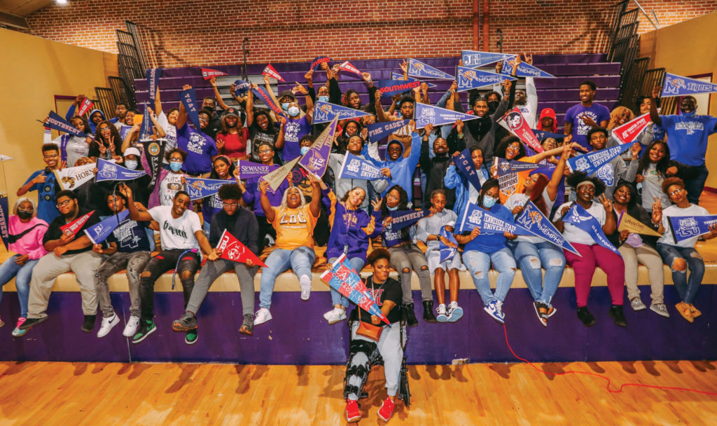 A group of college-bound students posing for a photo in a gymnasium.