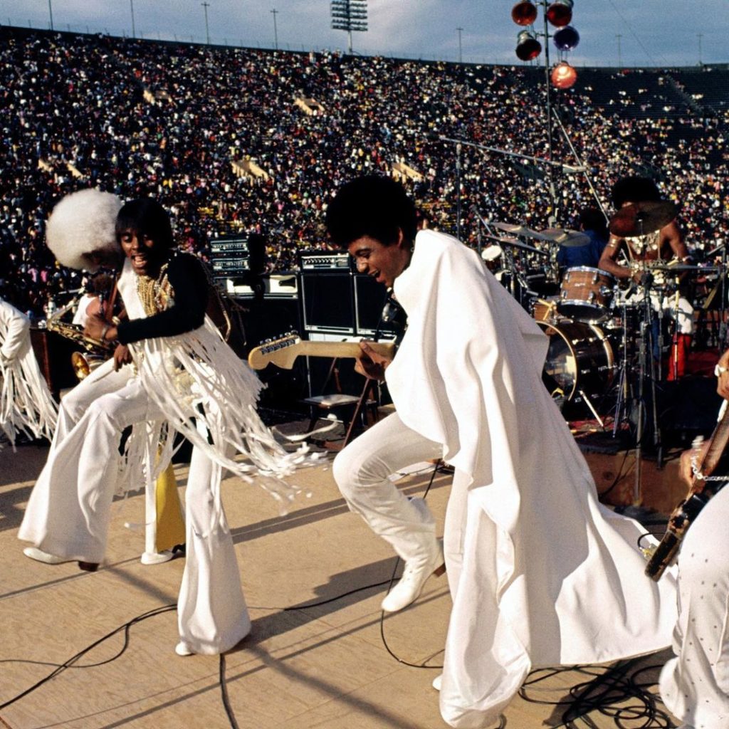 A group of people dressed in white performing at a stadium during a Stax Museum event.