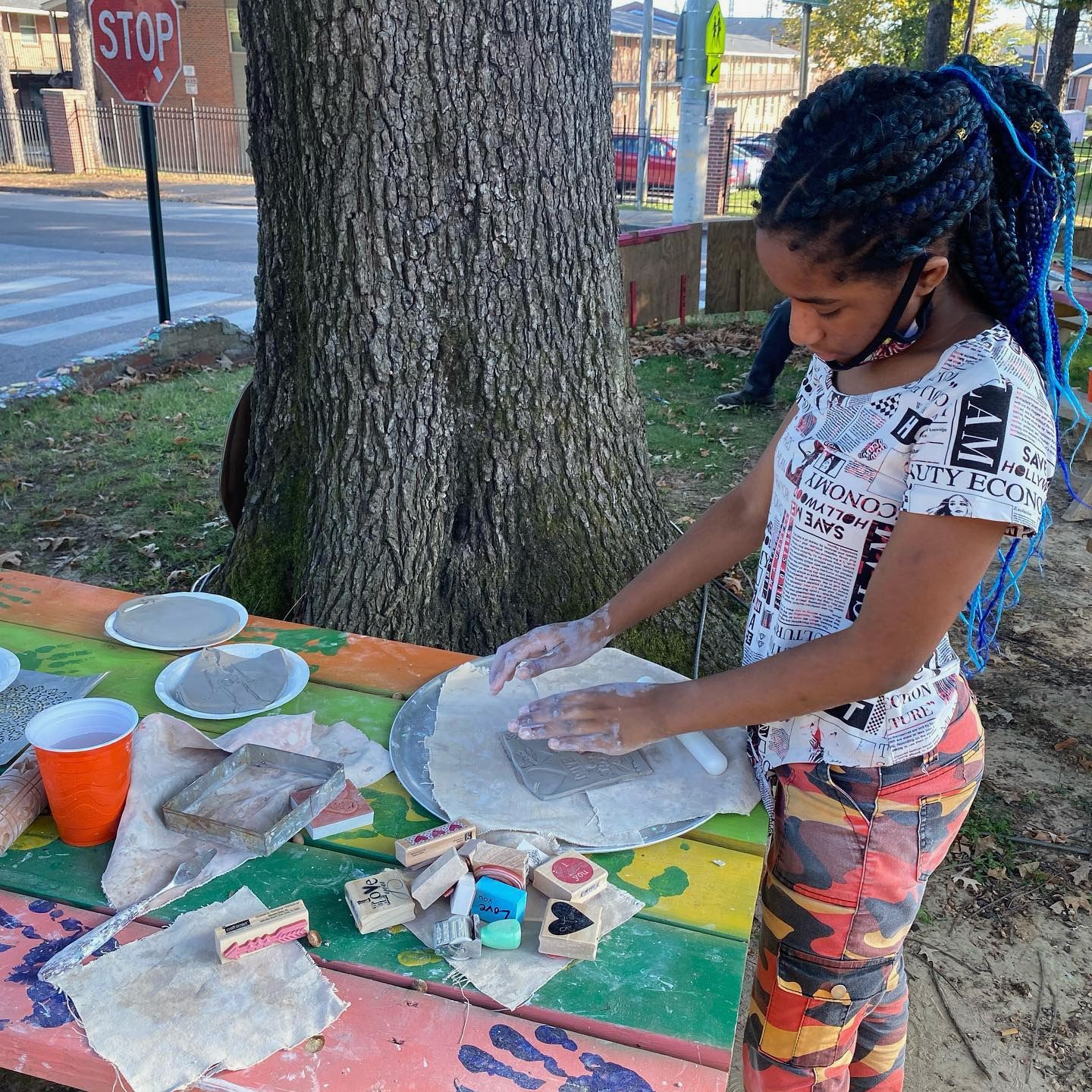A girl with dreadlocks showcasing her pottery skills during Summer of Service.