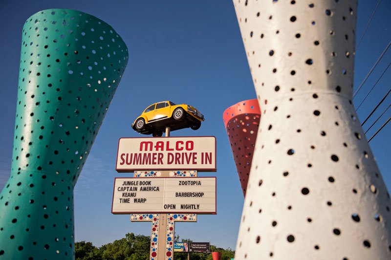 A sign with a car and a sign that says marico summer drive in.