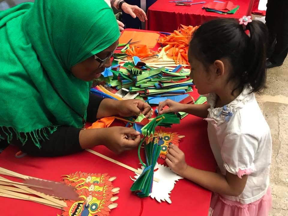 A young girl is making a chinese lantern at Crosstown Arts.
