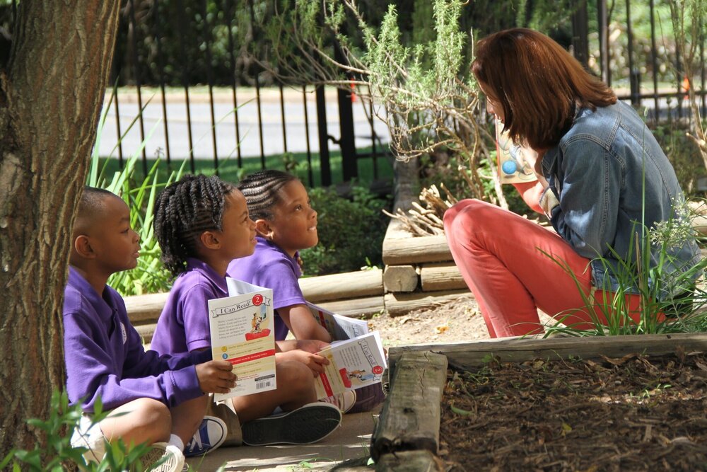 A woman reading to children at New Hope Christian Academy.