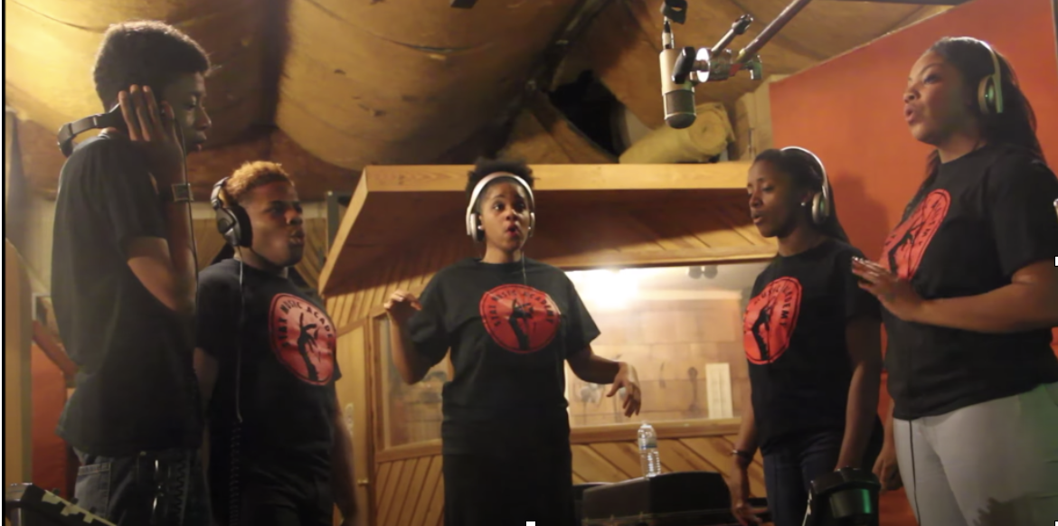 A #MusicMustContinue group singing in a recording studio.