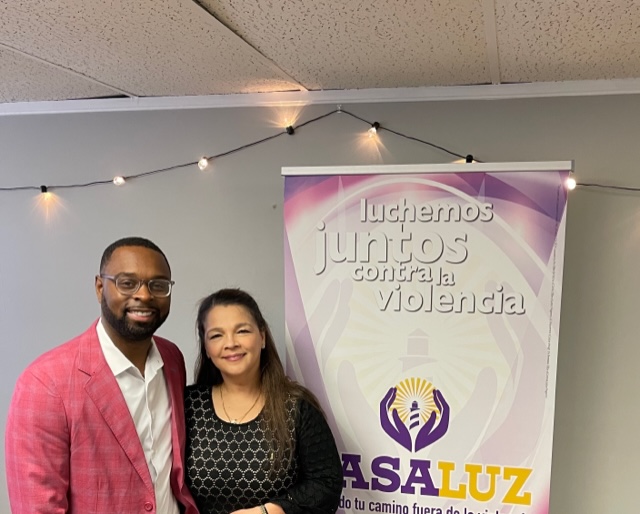 A man and woman representing the Latinx Community in Memphis standing in front of a banner for asaluz.
