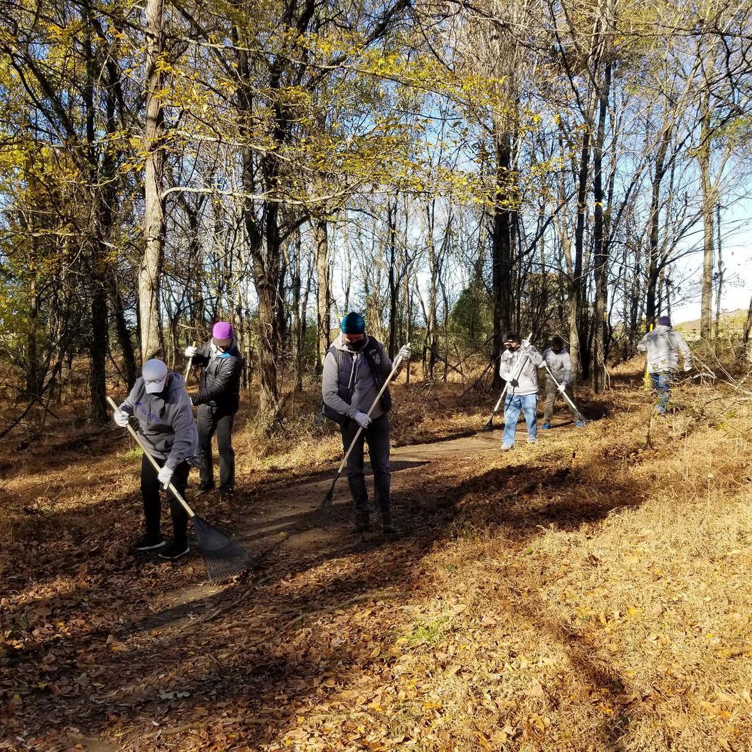 A group of people serving Memphis in December with shovels in the woods.