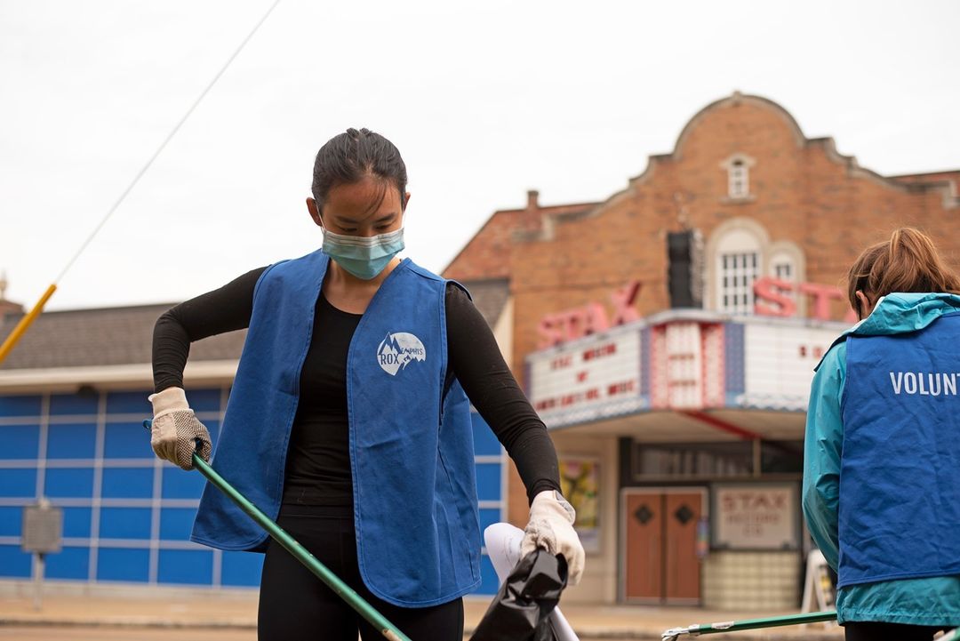 A woman wearing a face mask is sweeping a street in Memphis to make a difference during the pandemic.