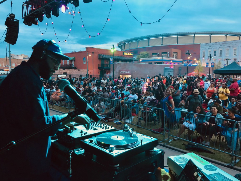 A DJ performing on stage in front of a crowd at Black Memphis.
