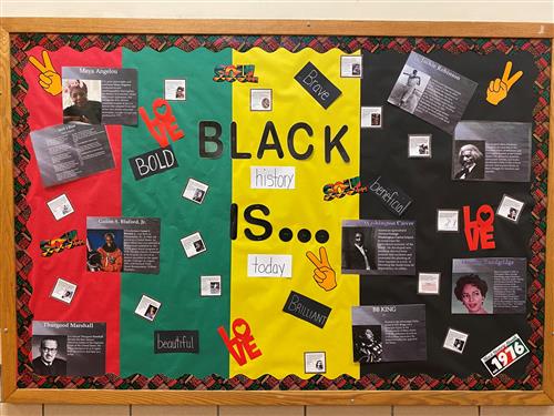 A black history month bulletin board with pictures and posters.