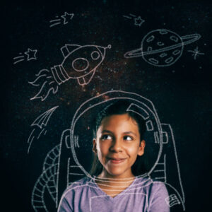 A little girl in an astronaut suit using her imagination to gaze up at the stars and planets.