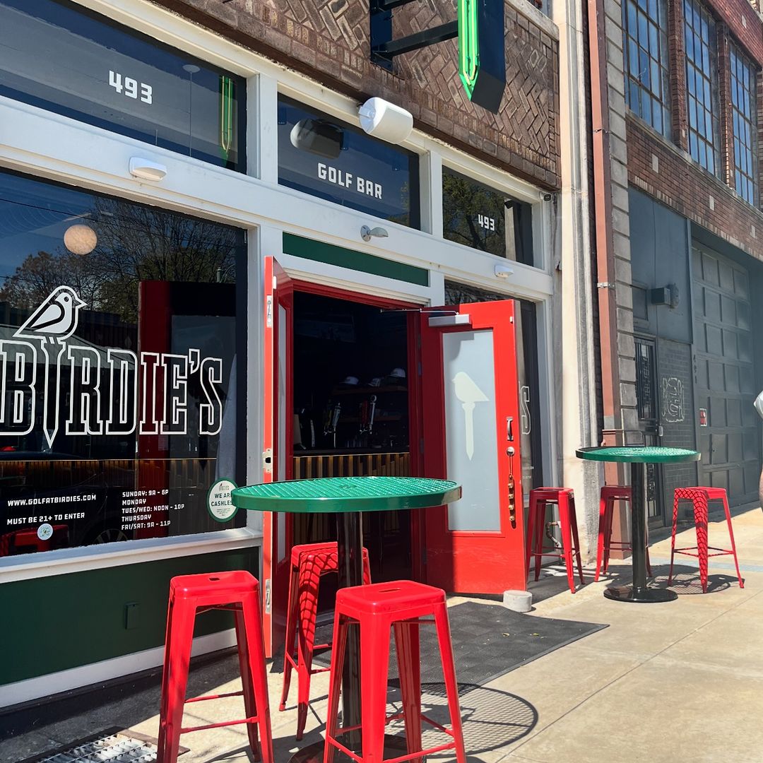Exterior of "birdies" golf bar with red stools and tables on the sidewalk, prepared for a Memphis Grizzlies watch party.