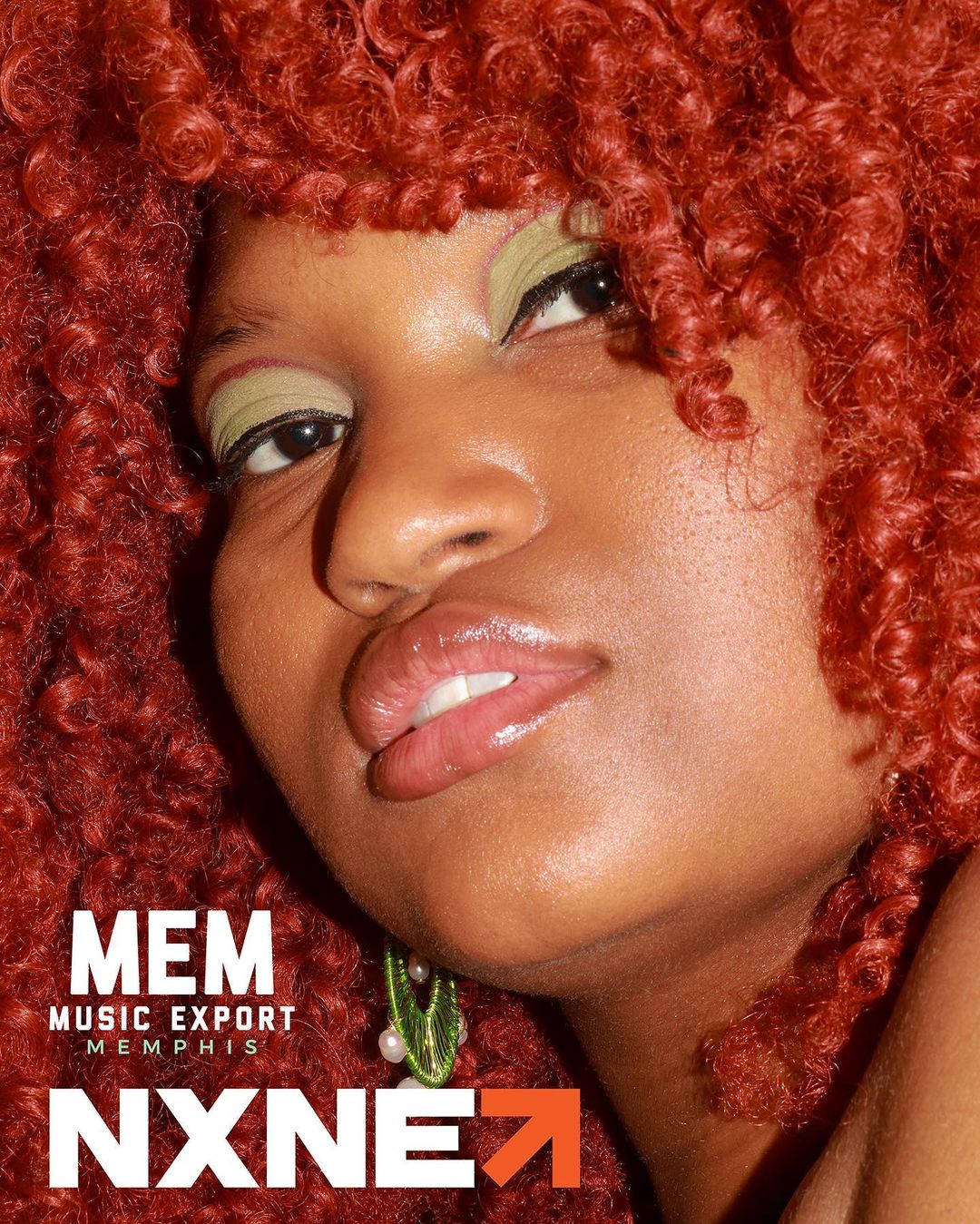A woman with red afro hair is posing for a photo at a MEM party wearing a tambourine bash shirt.
