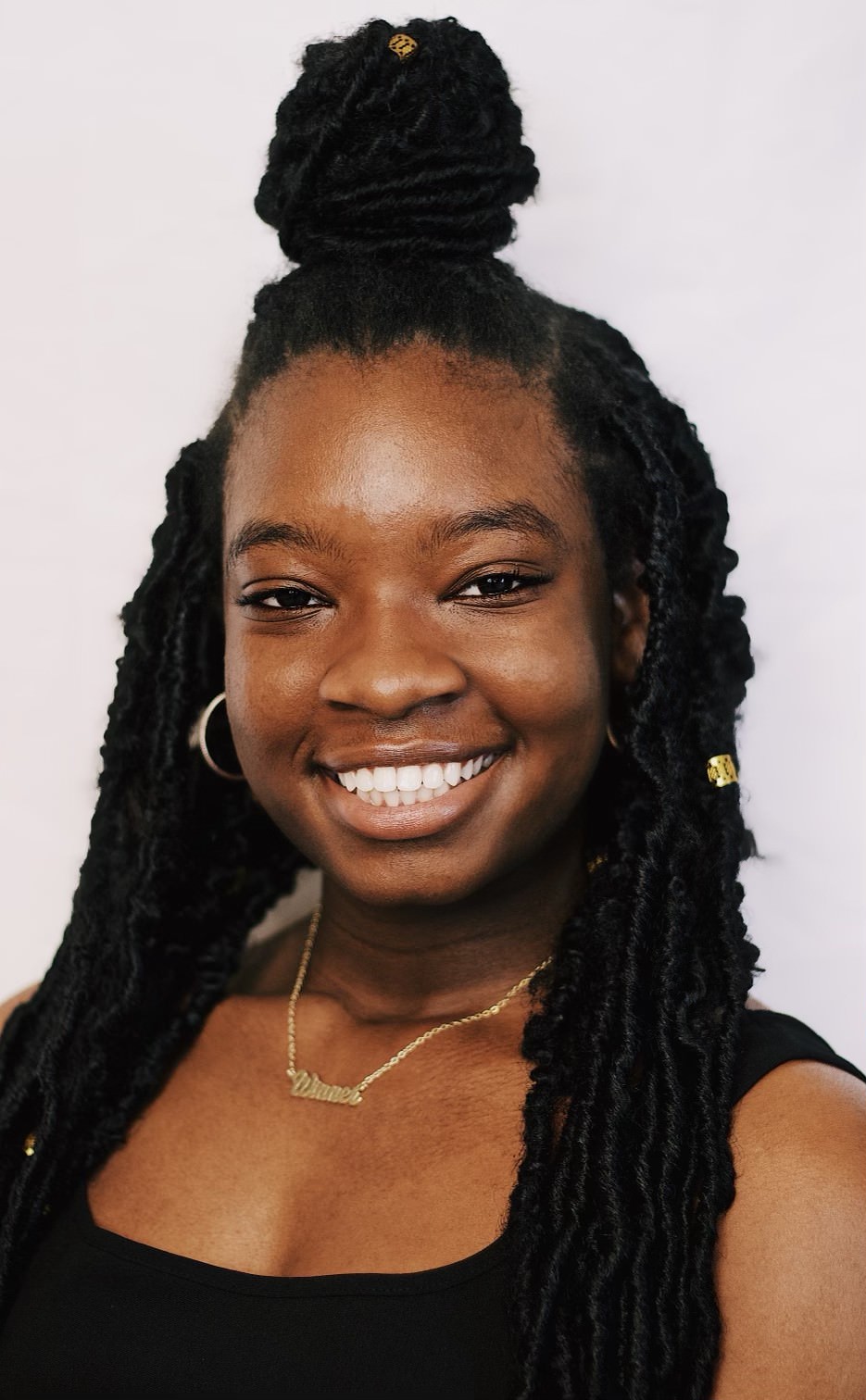 A young black woman smiling with dreadlocks named NexGen Yancey.