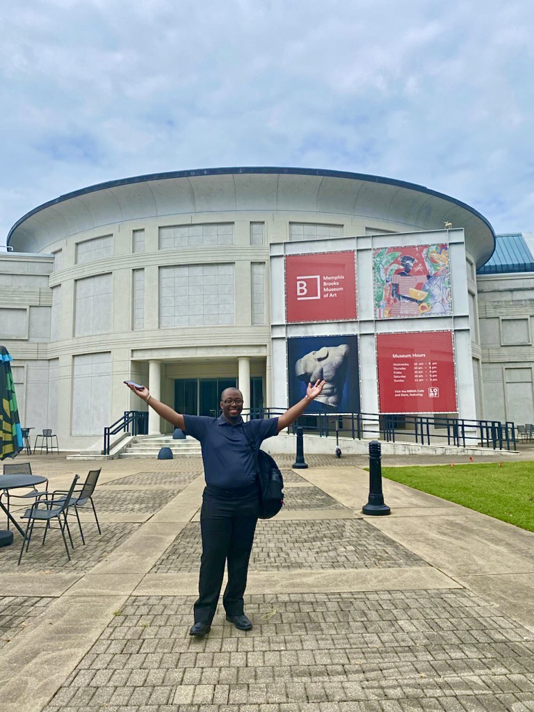 A man standing in front of a museum.
