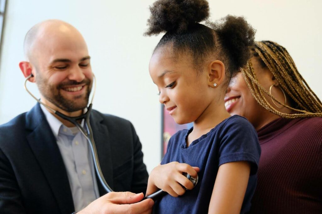A young girl is being examined by a doctor with a stethoscope, ensuring the rhythm of health.