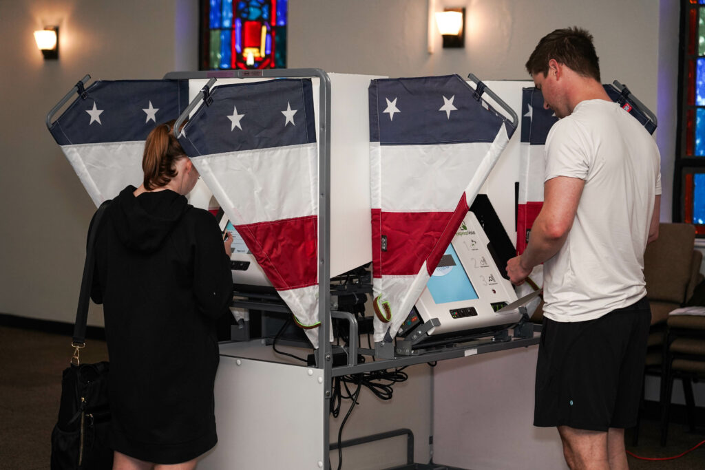 A man and woman are enthusiastically casting their votes at a voting machine in Memphis.