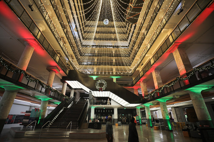 The atrium at the Holiday Market is lit up with green and red lights.
