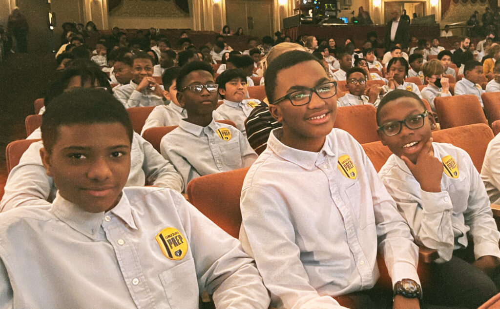 A group of boys in white shirts celebrating local education at the 2nd Annual Tie Ceremony at Grizzlies Prep.