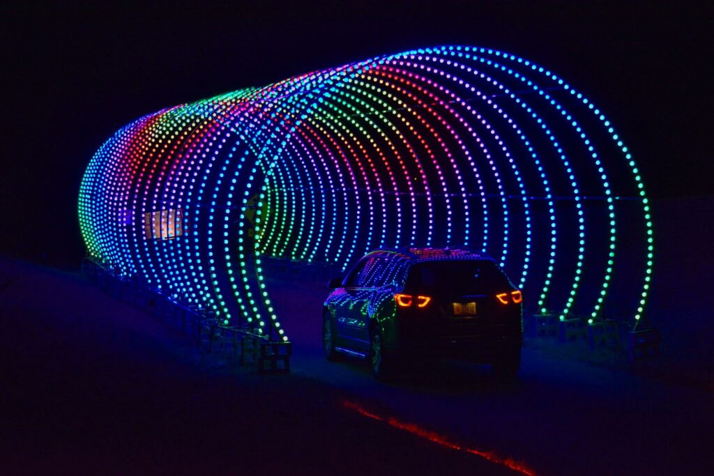 A volunteer-driven car driving through a tunnel of lights in Memphis.
