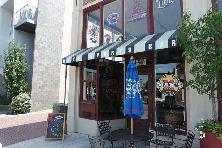 The front of a restaurant with tables and chairs, hosting a Memphis Grizzlies watch party.
