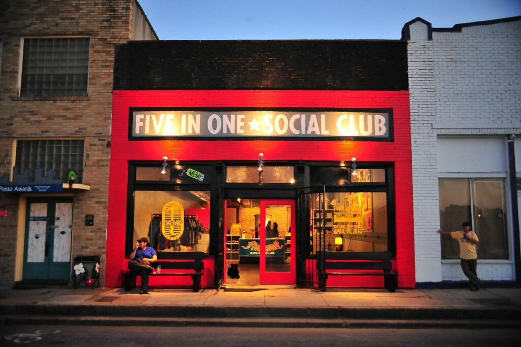 A festive red building adorned with a sign that reads "Five in One Social Club," offering holiday season finds.