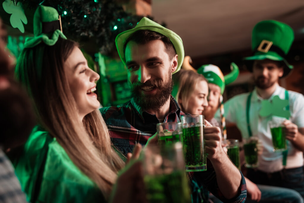 Group of friends enjoying St. Patrick's Day celebration with green attire and drinks during the spring festivals in Memphis.